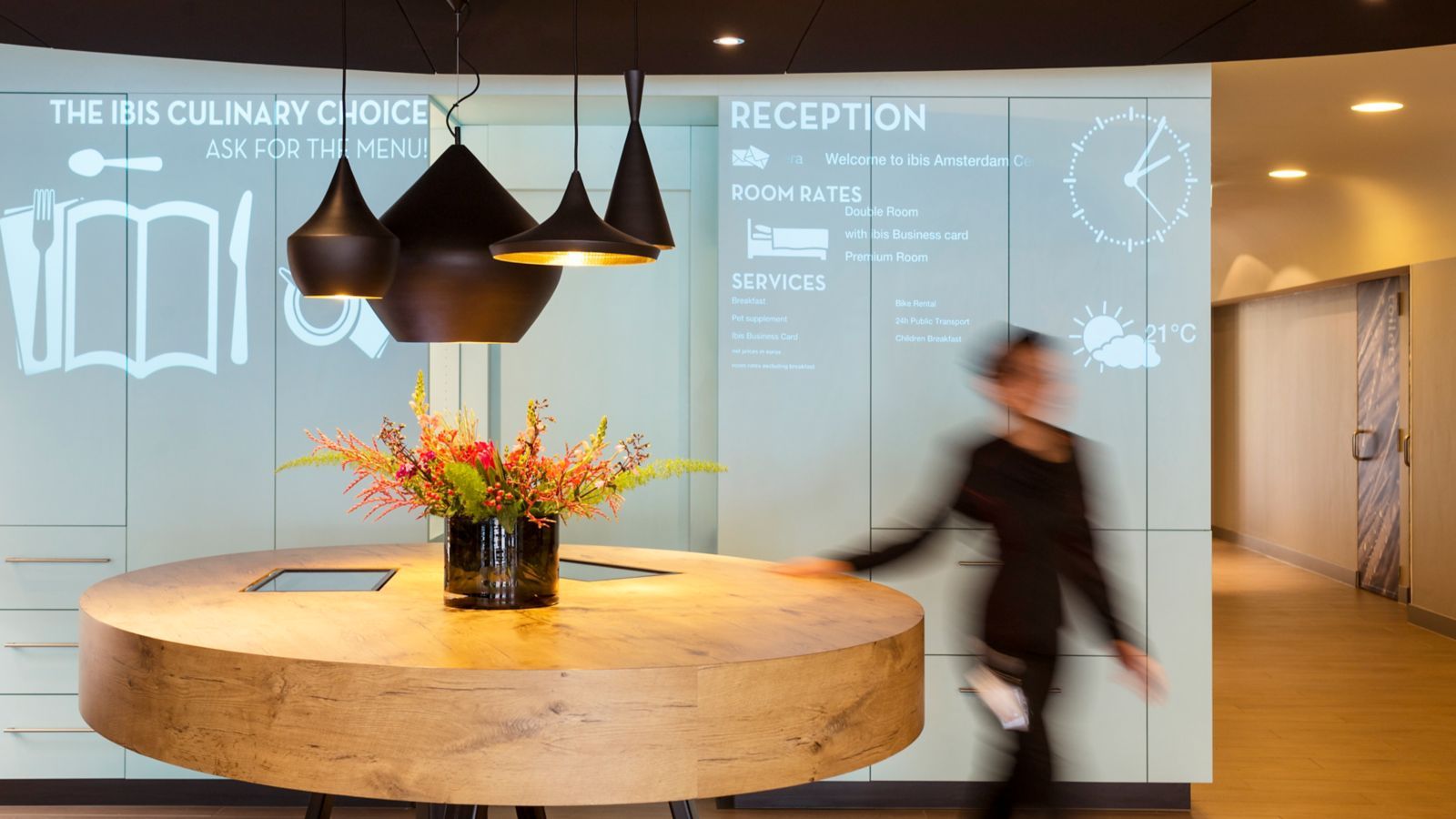 Lounge eines Accor Hotels mit großem Tisch und einer Person