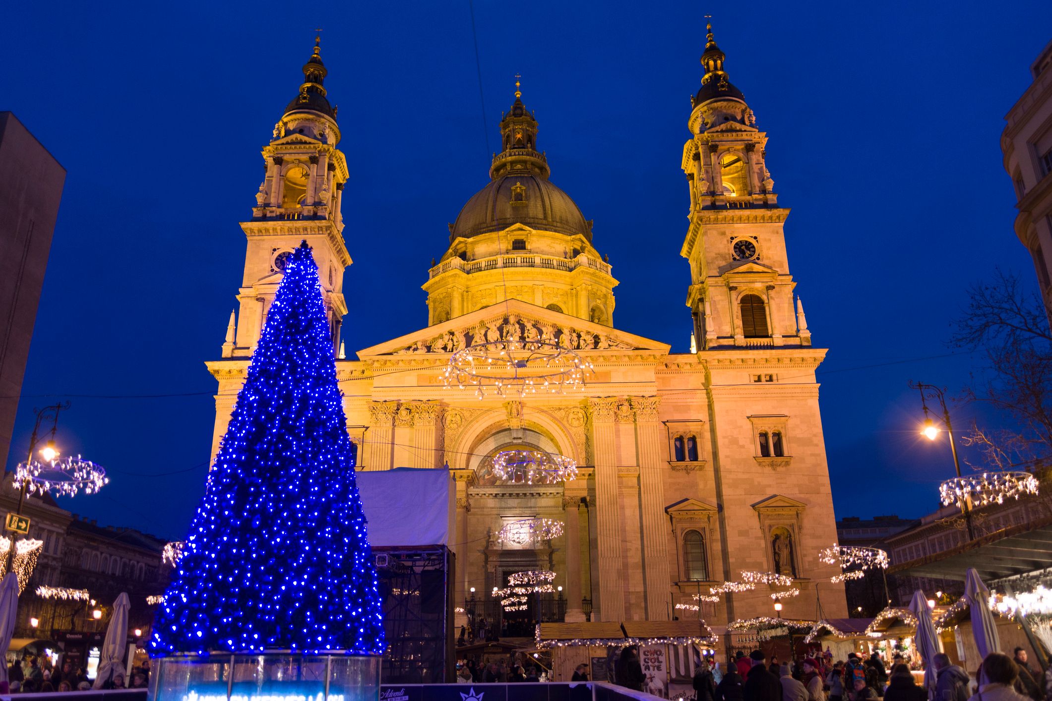 Die St. Stephans Basilika in Passau, nachts stimmungsvoll beleuchtet mit festlichem Weihnachtsbaum davor.