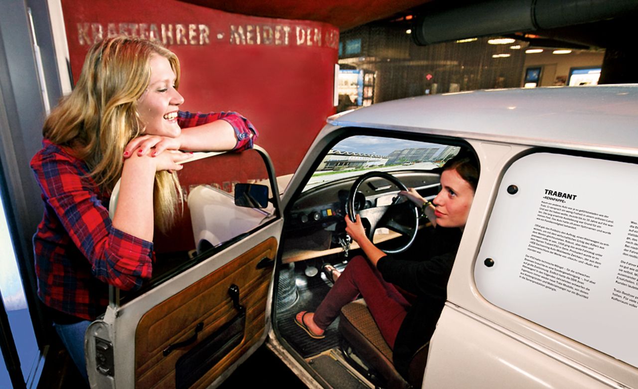 Zwei glückliche Frauen am und im Trabi des DDR Museums in Berlin