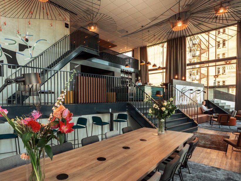 Die modern gestaltete Lobby des Hotels „the niu Fender“ mit industriellem Design und gemütlichen Sitzgelegenheiten.