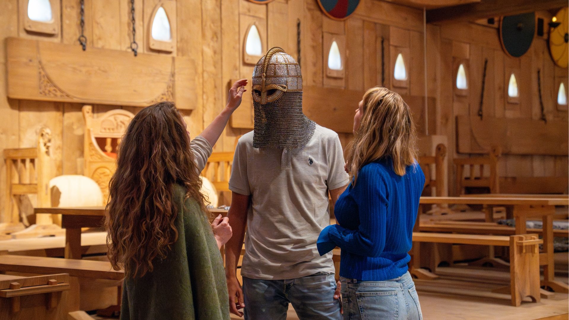 Zwei Frauen und ein Mann mit Ritterhelm im Lejre Land der Legenden 