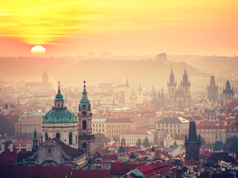 Panoramablick auf Prag bei Sonnenuntergang mit warmem Licht über der Stadt.
