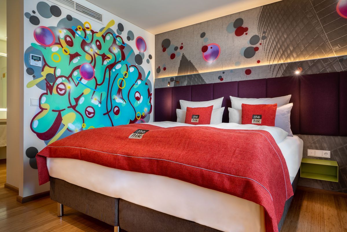 Einladendes Doppelzimmer im Hotel the niu Hide Berlin mit farbenfroher Einrichtung und urbanem Design.