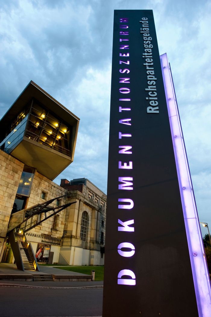 Säule mit leuchtenden Buchstaben vor dem Dokumentationszentrum