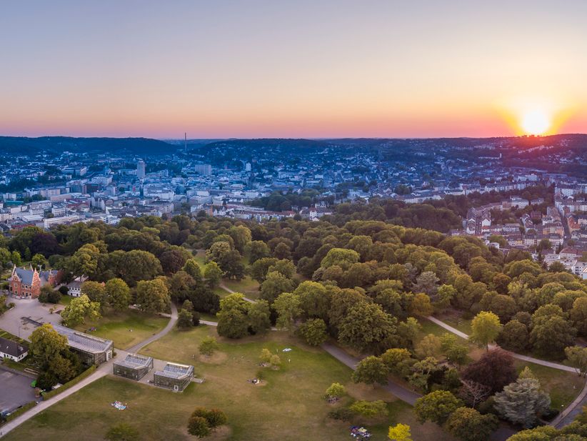 Panoramablick auf Wuppertal mit einem großen Park bei Sonnenuntergang