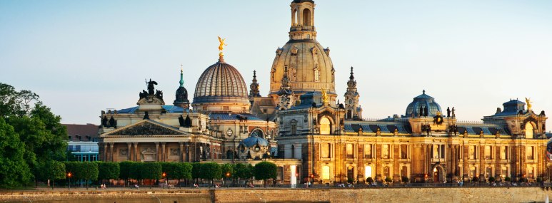Das Dresdner Elbufer mit der Frauenkirche erstrahlen im goldenen Licht des Sonnenaufgangs - BAHNHIT.DE, © getty, Foto: Nikada