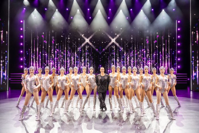 Damen auf der Bühne stehen in einer Reihe mit Anzugträger in der Mitte