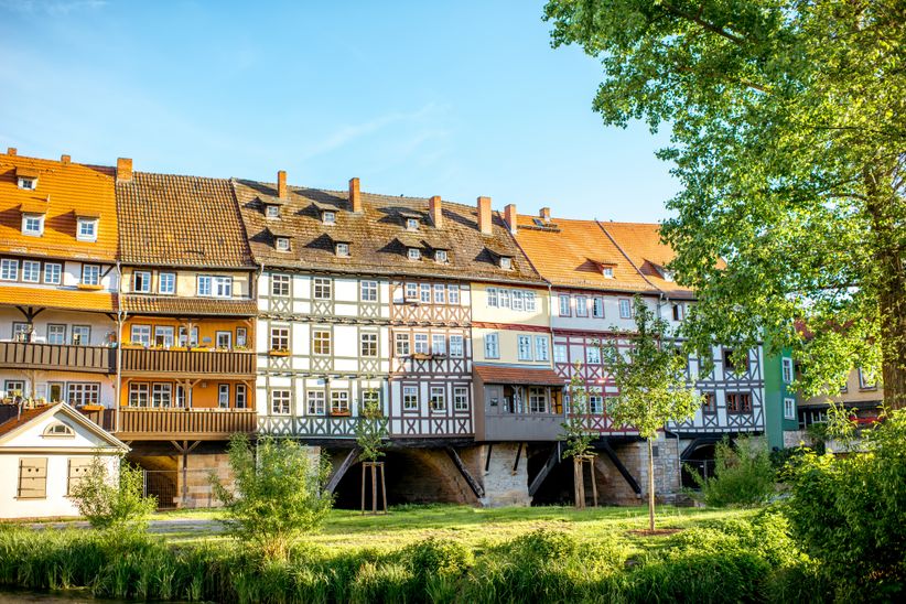 Blick auf die historische Krämerbrücke in Erfurt mit dicht aneinandergereihten Fachwerkhäusern über dem Fluss Gera