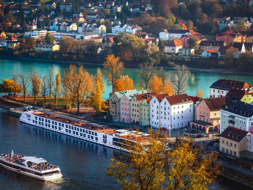 Panoramablick auf Passau mit einem Donaukreuzfahrtschiff und einem Fahrgastschiff auf der Donau.