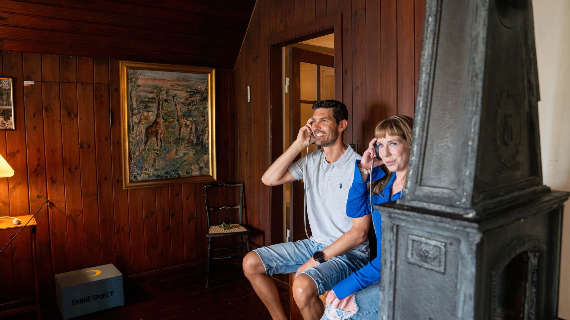 Zwei Personen mit Kopfhörern hören Audioangebot im Karen Blixen Museum