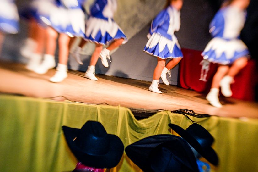 Nahaufnahme einer Karnevalssitzung mit Funkenmariechen Tänzerinnen im Hintergrund