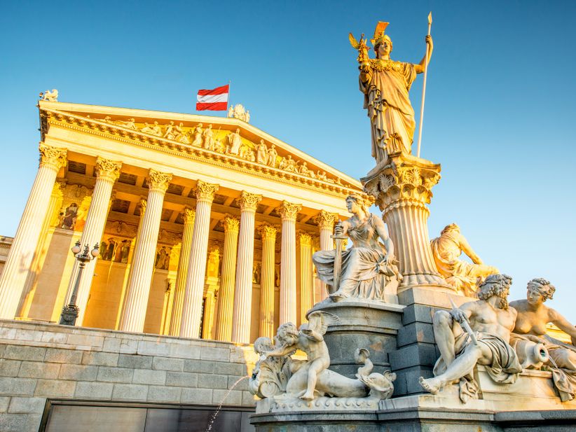 Parlament in Wien während der goldenen Stunde, Statue davor