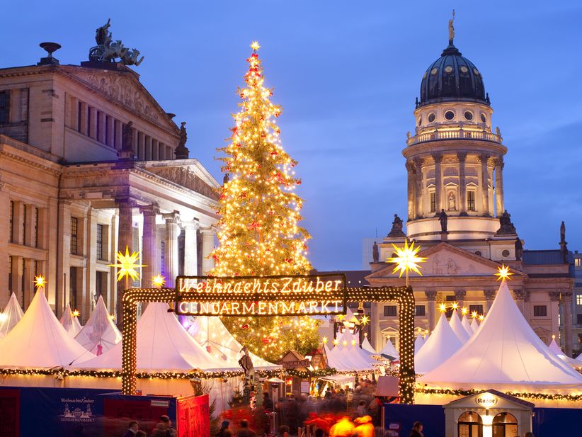 Eingang zum Weihnachtsmarkt am Gendarmenmarkt Berlin mit festlicher Beleuchtung in der Dämmerung
