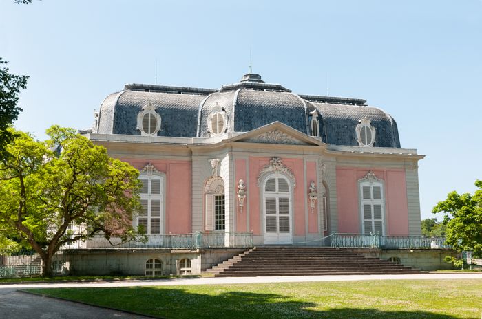 Rosa Schloss Benrath bei Sonne mit Wiese und Bäumen