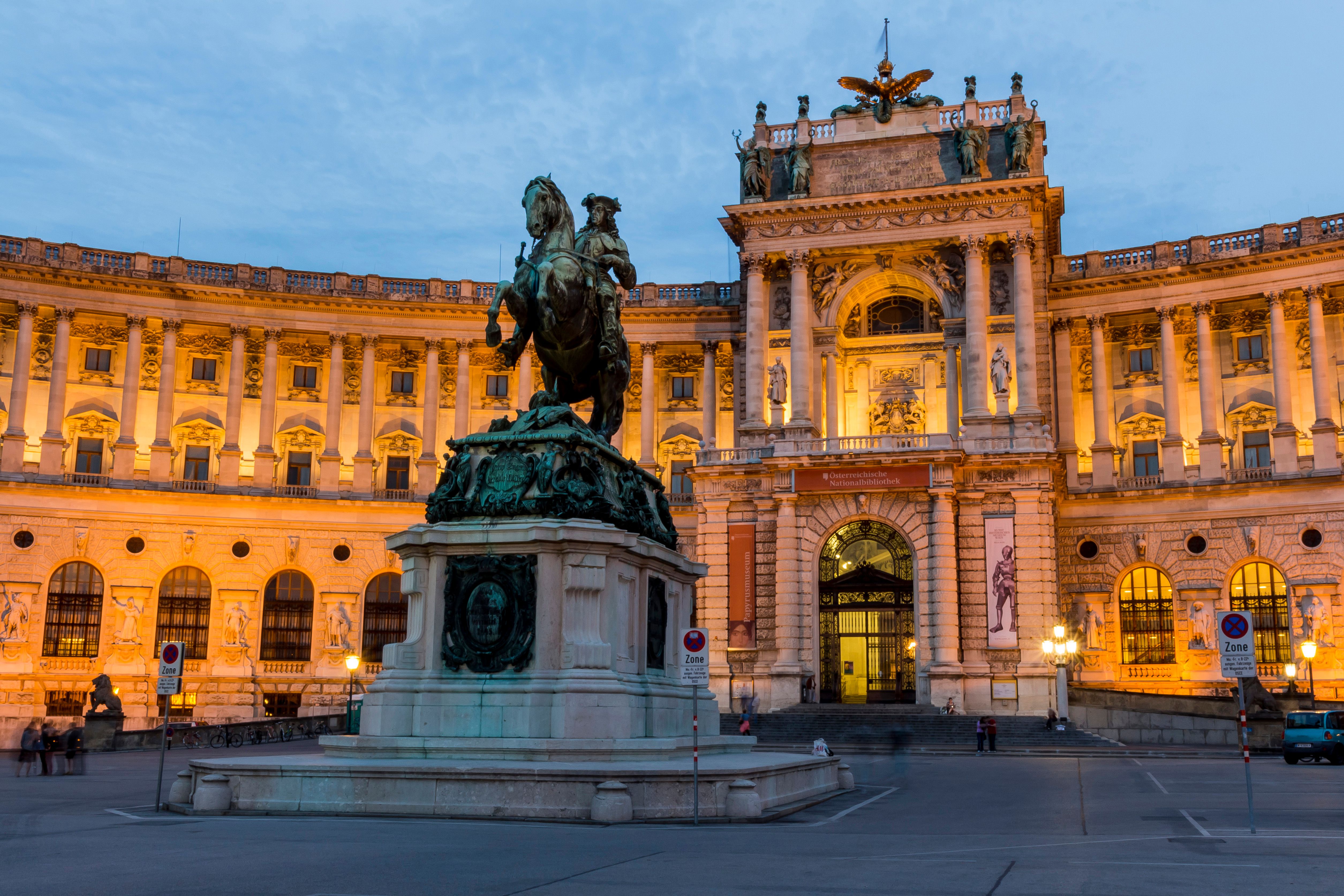 Beleuchtete Hofburg Wien am Abend und Reiterstatue davor