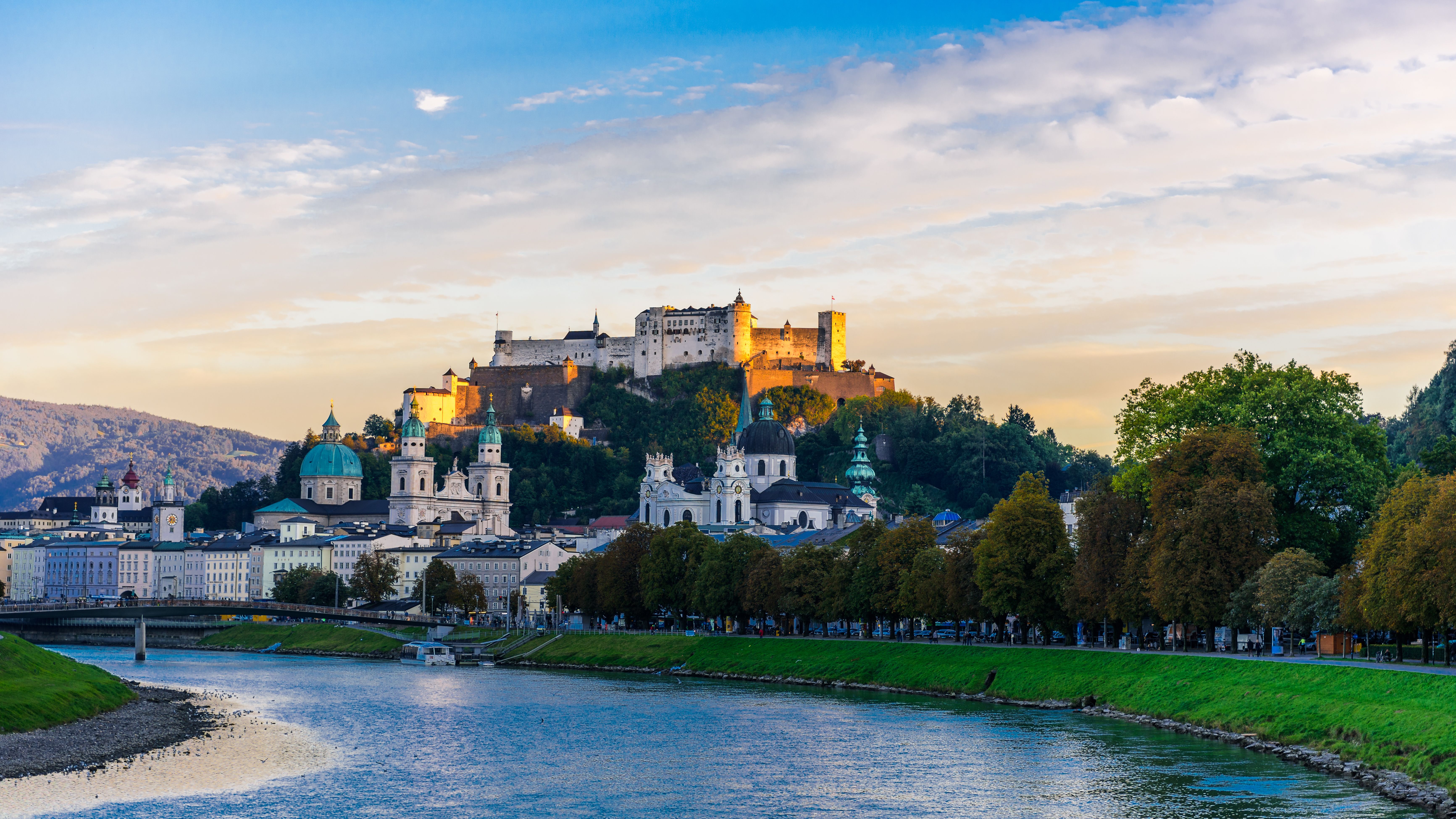 Festung Hohensalzburg über Fluss und Stadt auf einem Berg am Abend