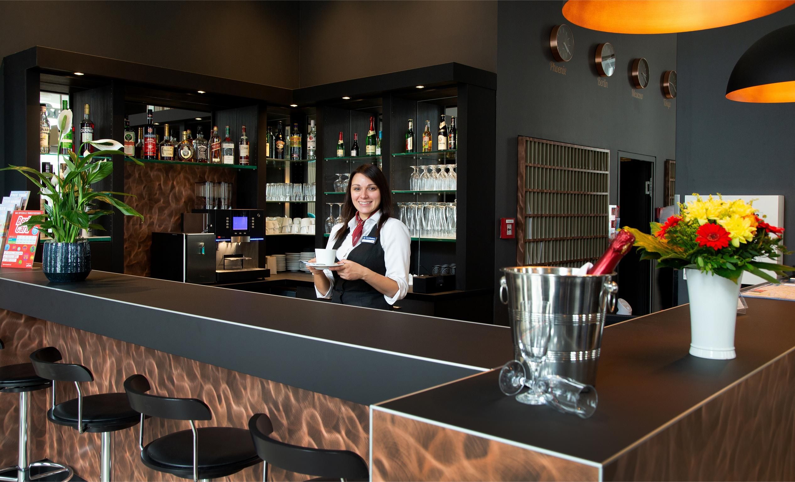 Schicke Bar im Best Western Hotel mit lächelnder Barkeeperin