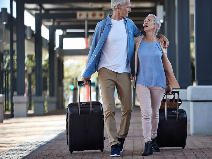 Menschen mit Koffern laufen vom Bahnhof