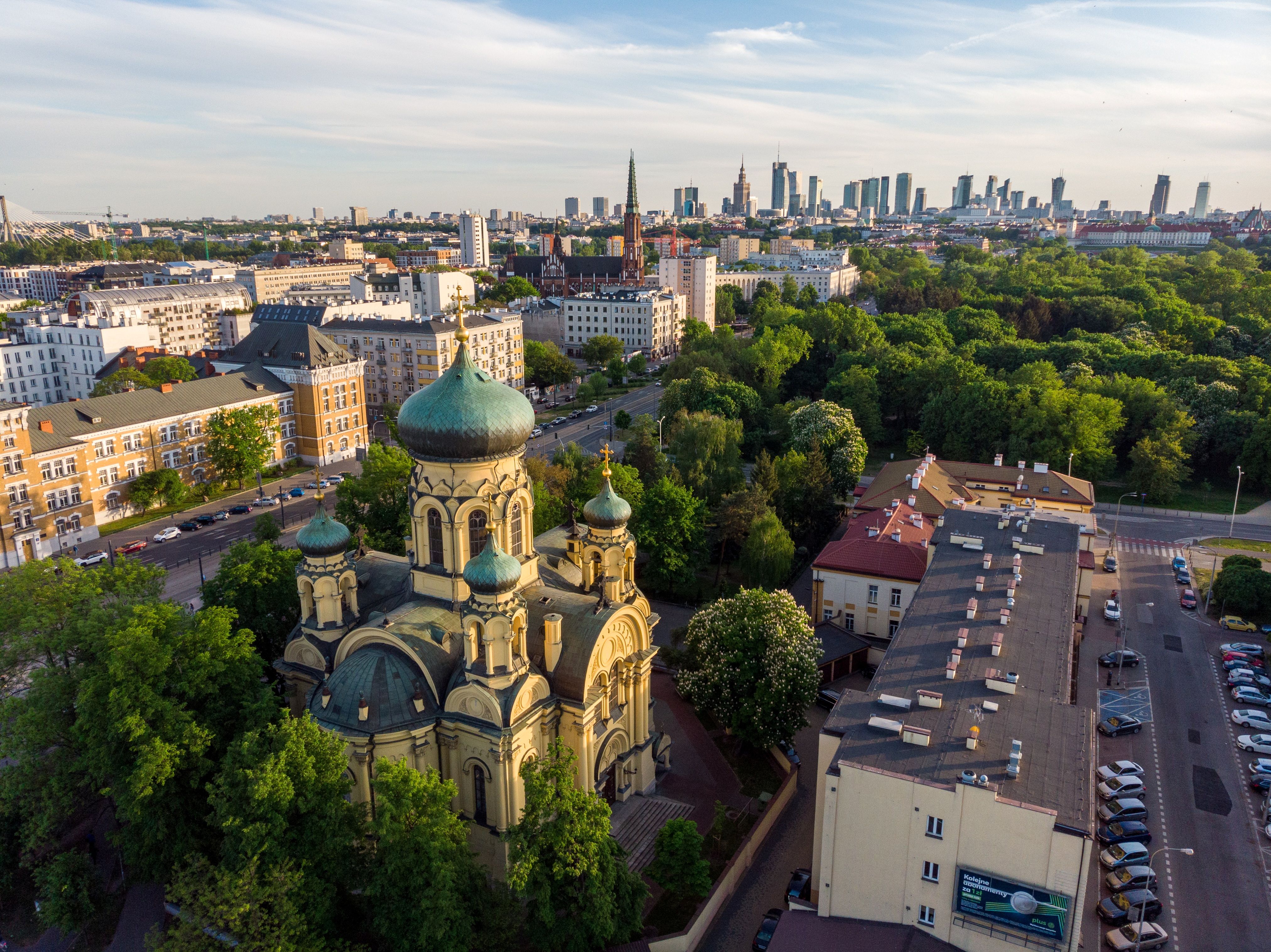 Die orthodoxe Kirche der Heiligen Maria Magdalena in Warschau mit ihren charakteristischen Zwiebeltürmen und goldenen Kuppeln vor blauem Himmel.