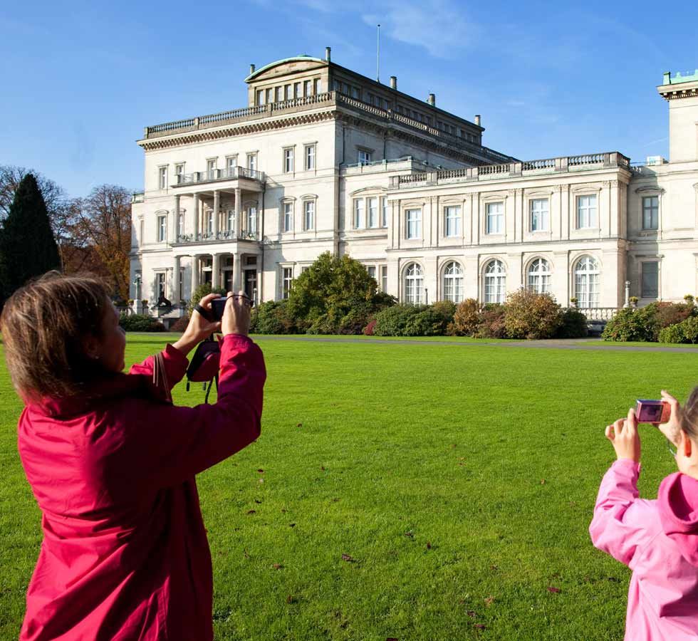 Kind und Frau machen ein Foto von der Villa Hügel in Essen