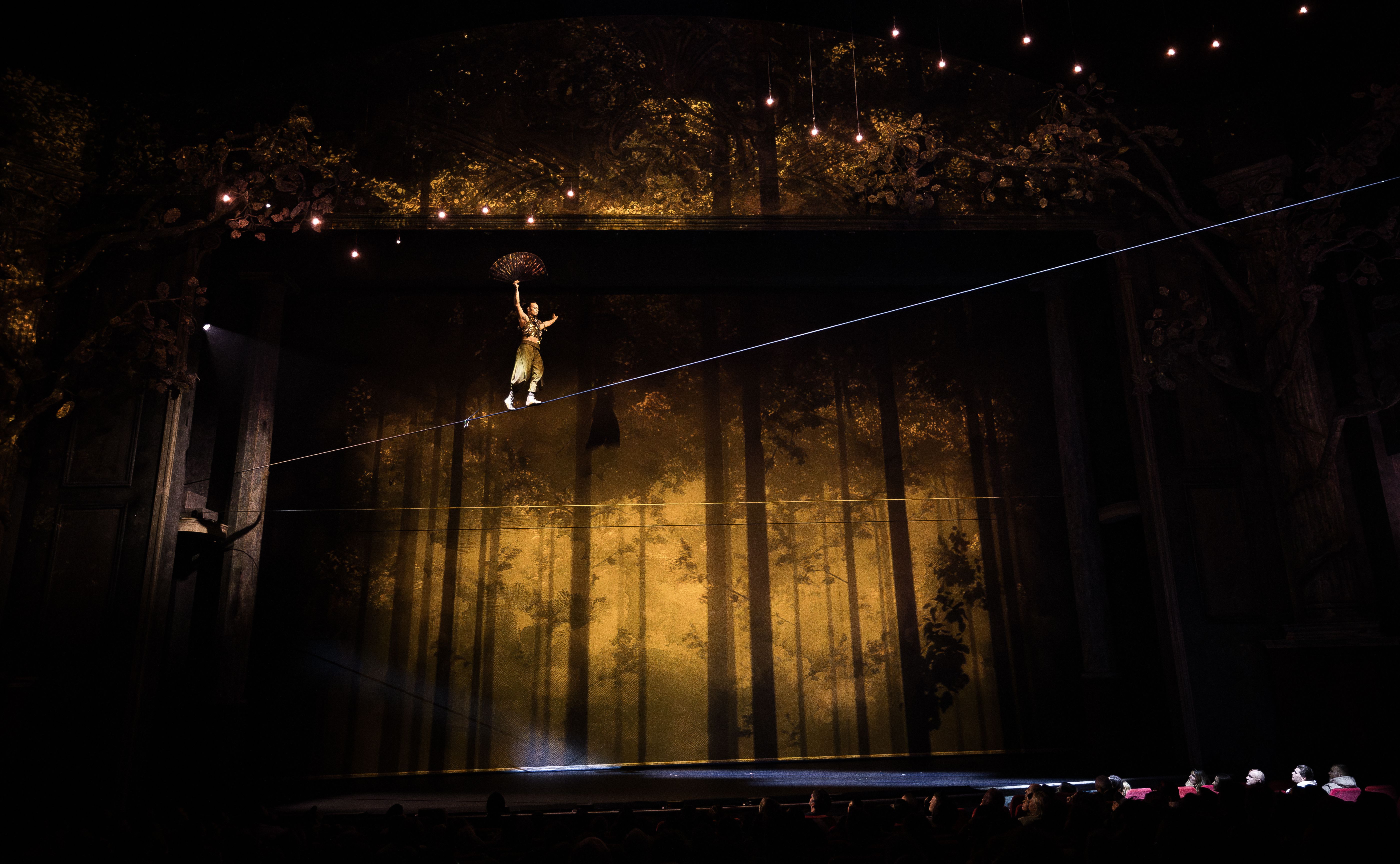 Szenenbild ein Mann balanciert auf dem Hochseil über die Bühne