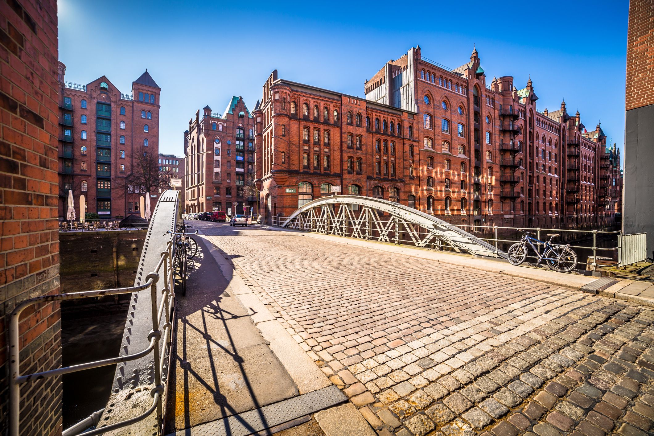 Stahlbrücke mit Pflastersteinboden in der Speicherstadt in Hamburg bei Sonne