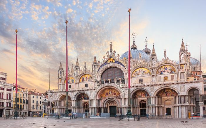 Die Fassade des Markusdoms in Venedig mit ihren fünf reich verzierten Portalen, goldenen Mosaiken und den markanten Kuppeln – ein Meisterwerk byzantinischer Architektur auf dem Markusplatz.