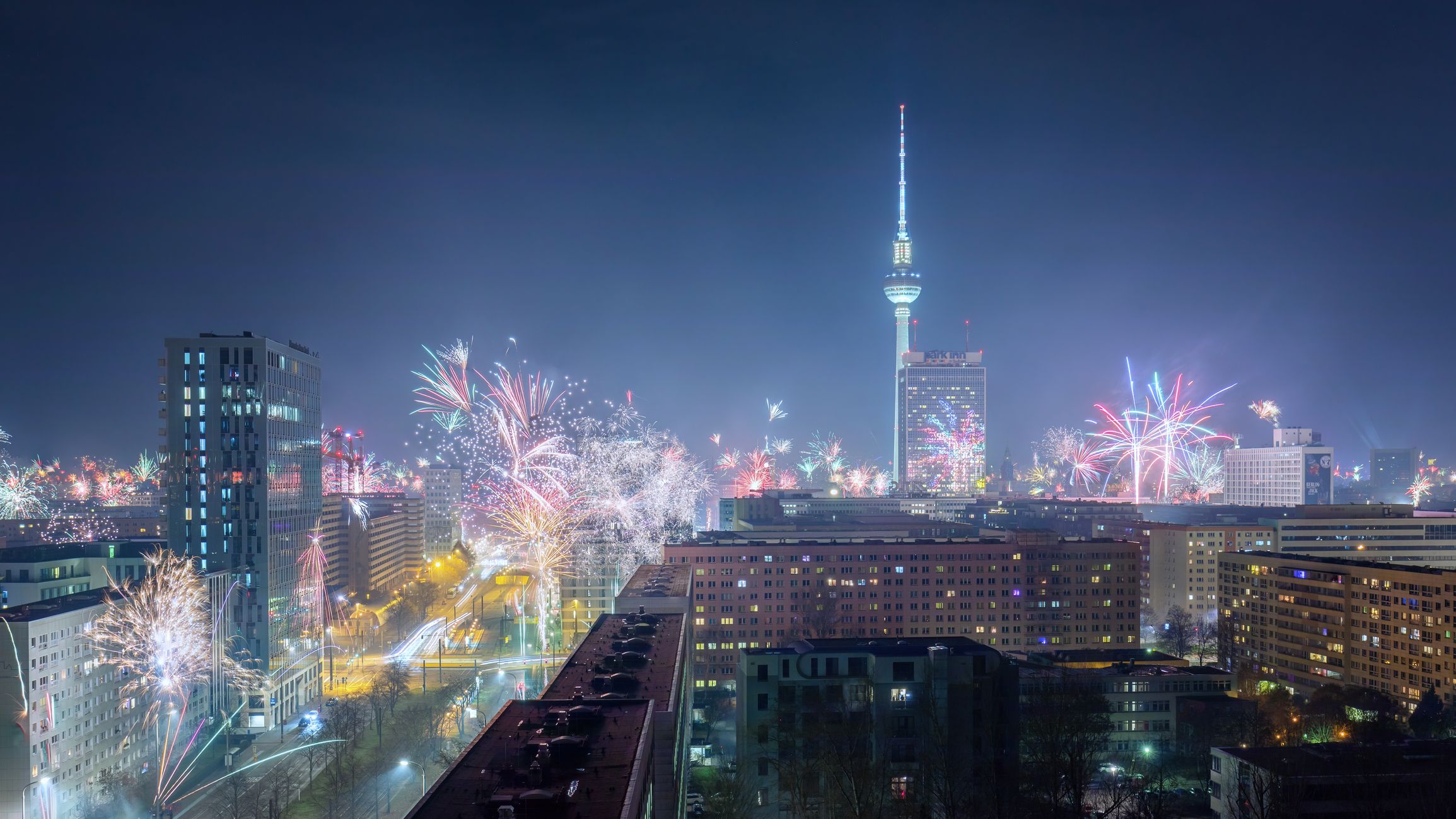 Feuerwerk über Berlins Stadtsilhouette bei Nacht mit beleuchtetem Fernsehturm