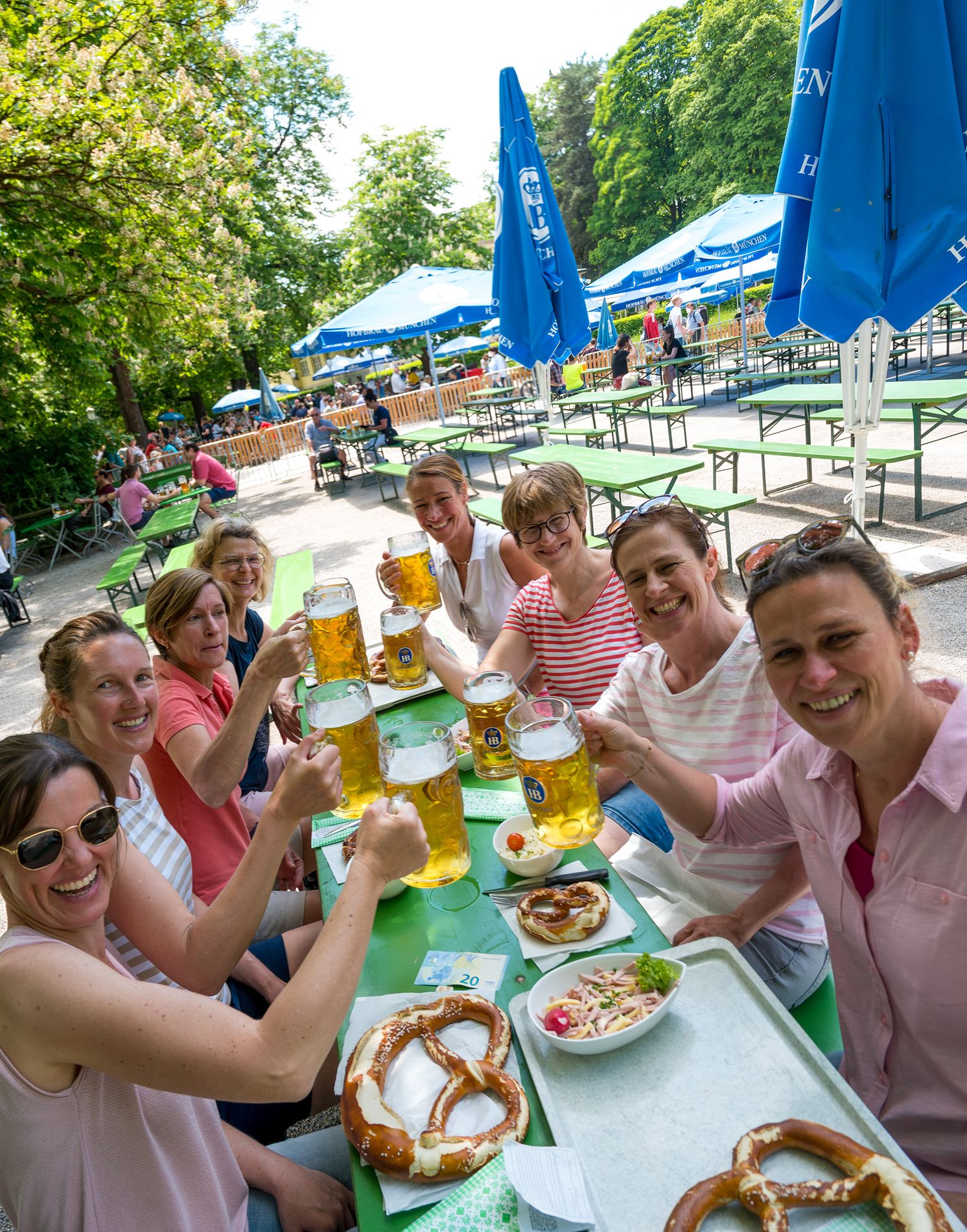 Eine entspannte Gruppe von Teilnehmern der Radltour bei einer Pause im sonnigen Biergarten am Chinesischen Turm in München.