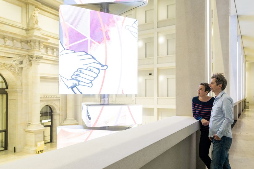 Mann und Frau im Foyer des Humboldt Forums Berlin an einer Brüstung stehend