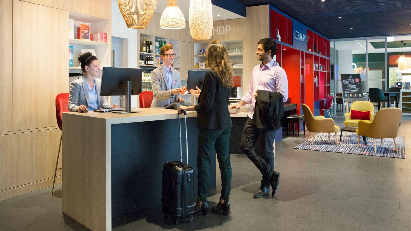 Check-in-Situation mit Hotelpersonal und Gästen in einem Accor Hotel 