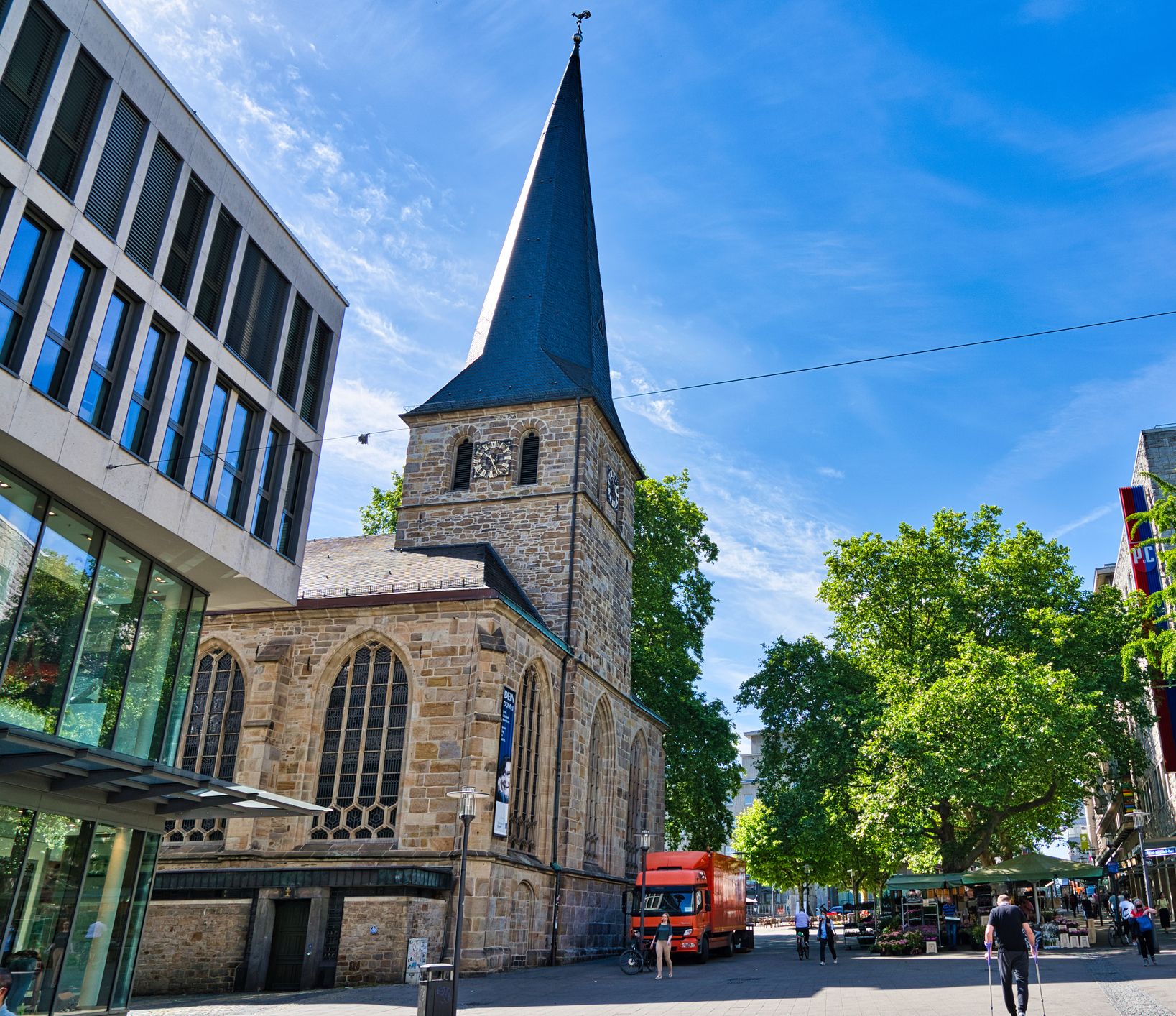 Innenstadt in Essen mit Shop, der Kirche St. Johann Baptist und Bäumen