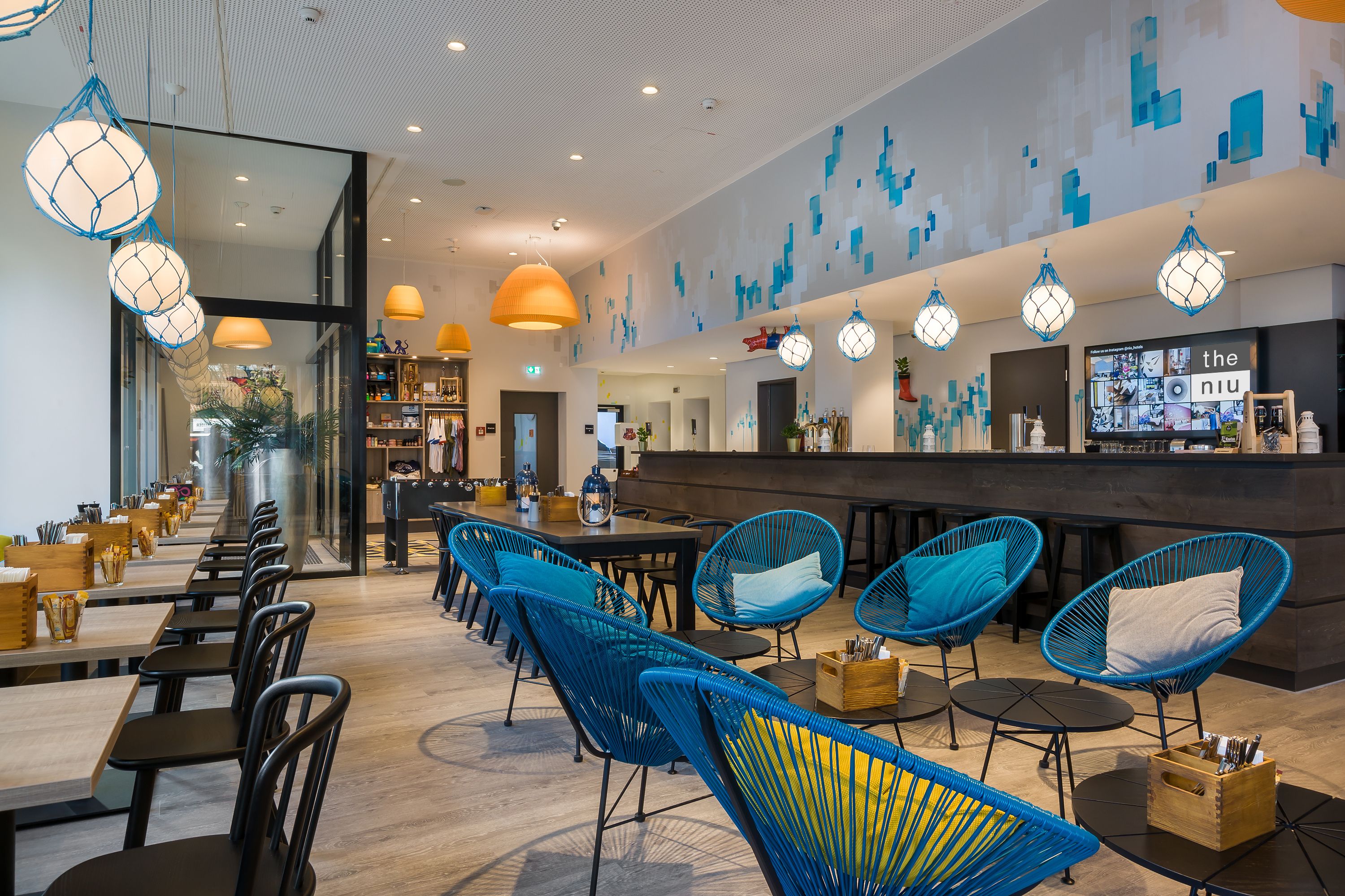 Moderne, maritim gestaltete Lobby des Hotels the niu Welly in Kiel mit stylischen Sitzmöbeln, Holzelementen und verspielten Details im Hafen-Stil.