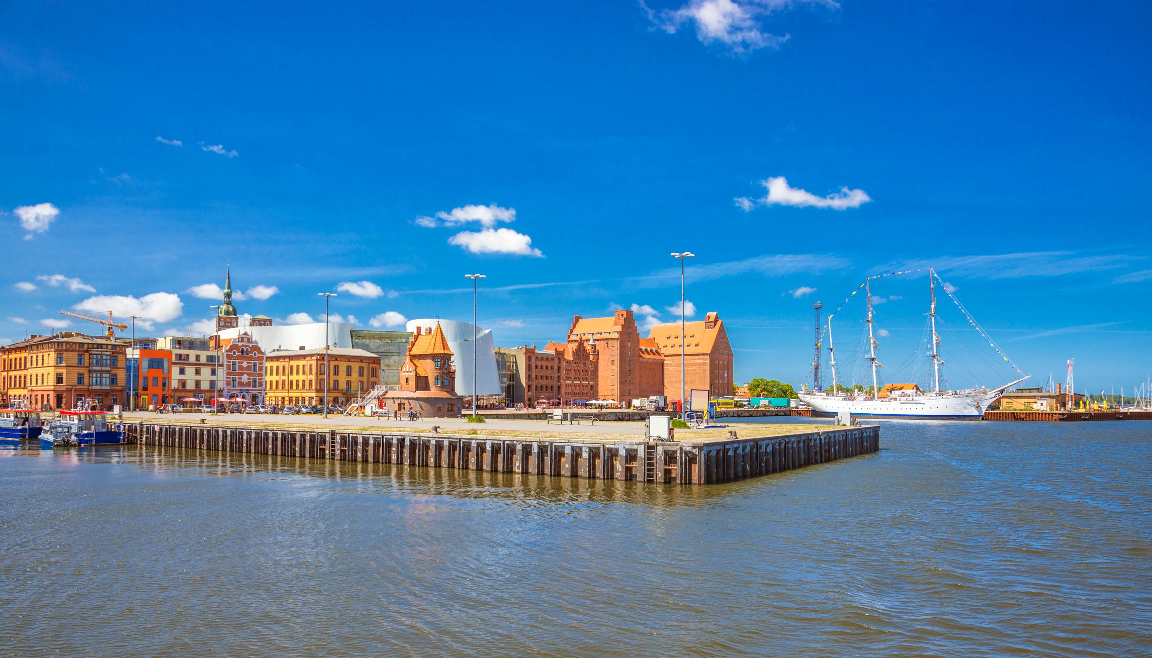 Hafen von Stralsund mit anliegenden Segelbooten, alten Backsteinspeichern und maritimem Flair an der Ostseeküste.