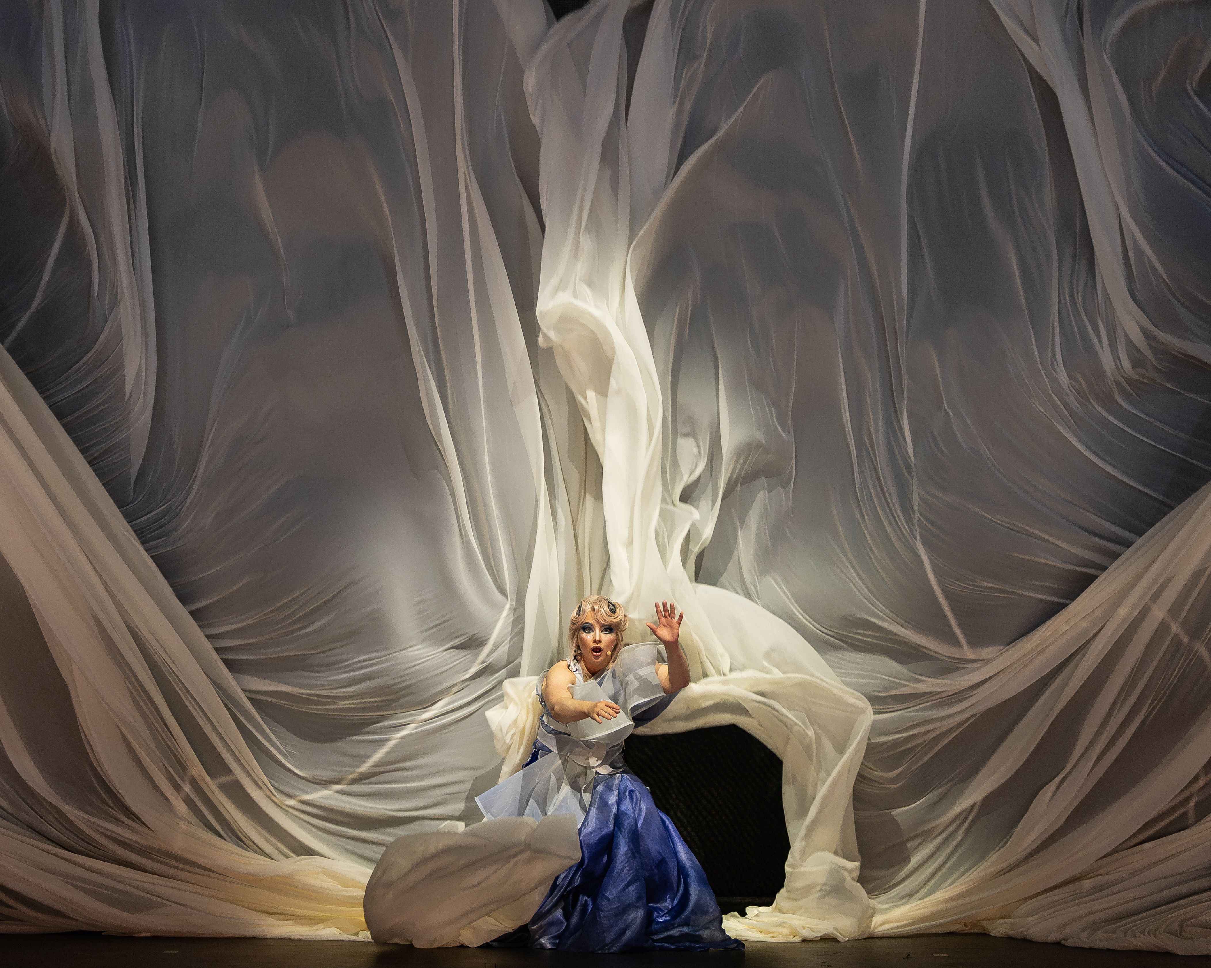 Szenenbild eine Frau ist umgeben von einem weißen Vorhang