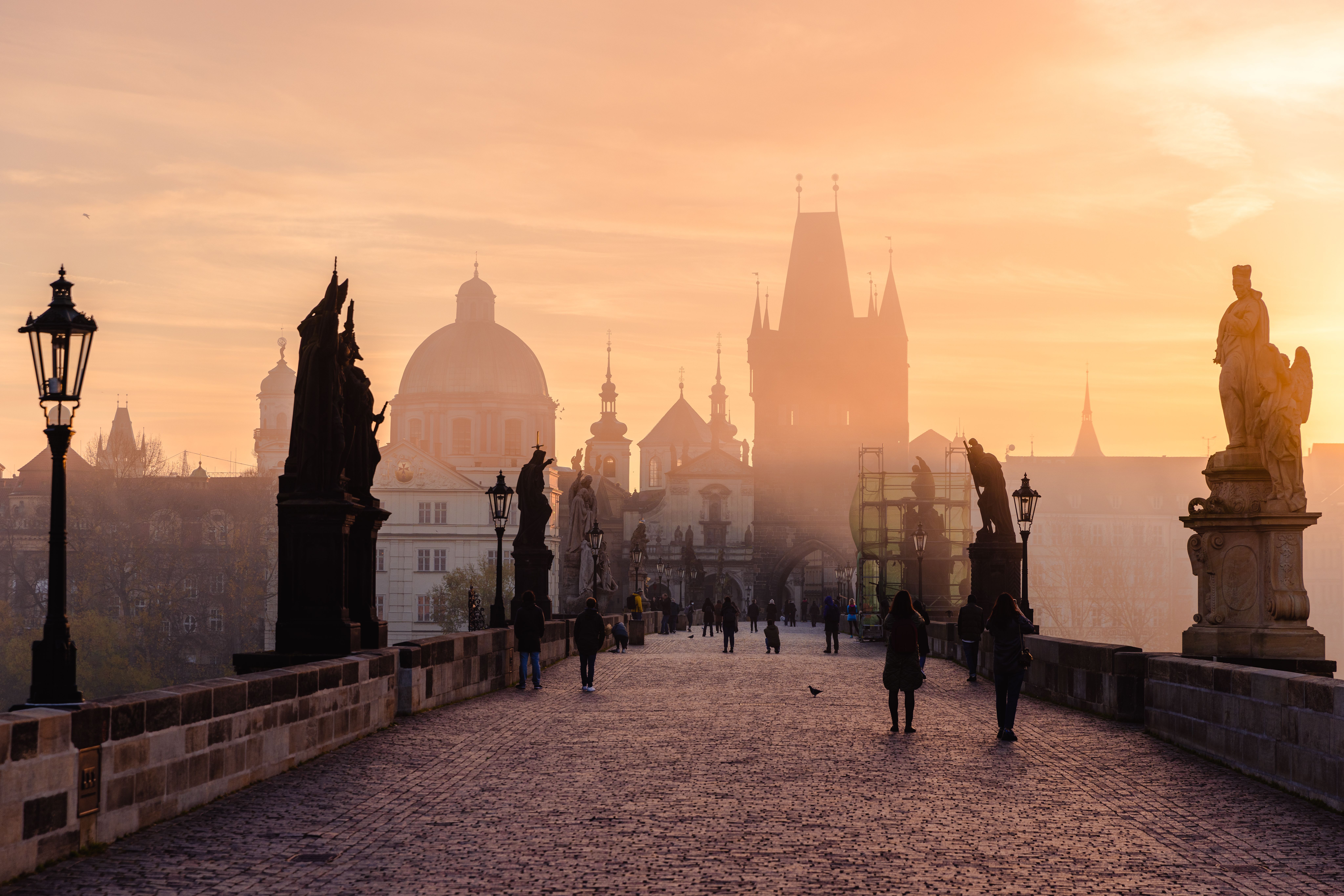 Karlsbrücke in Prag im warmen Abendlicht, mit Blick auf die historischen Türme.