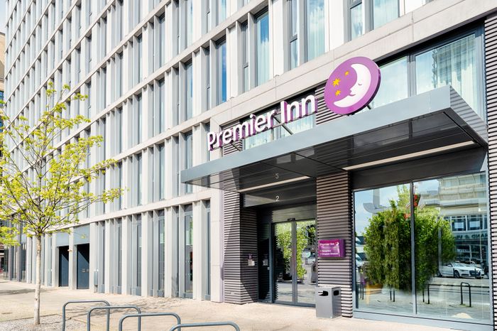 Eingangsbereich des Premier Inn Hotels mit automatischen Glastüren und beleuchtetem Logo über dem Eingang