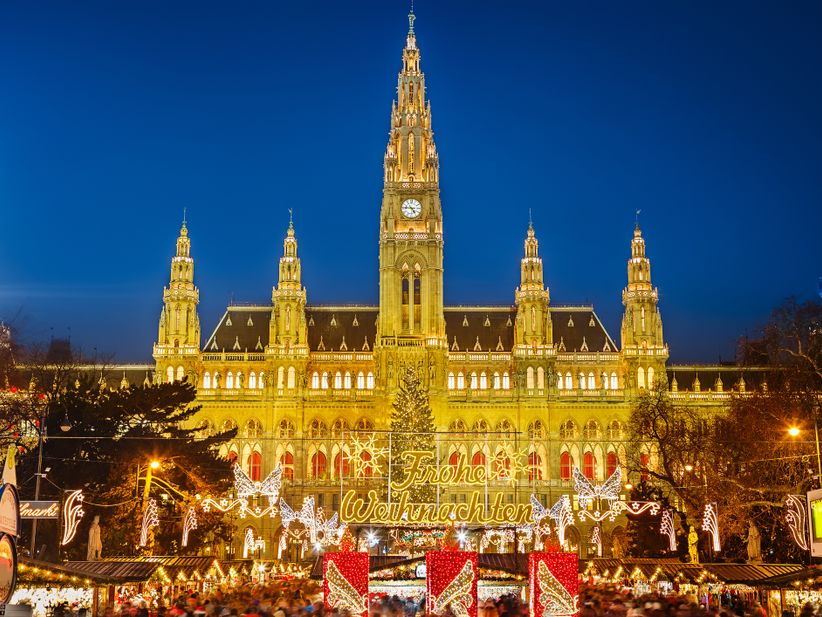 Weihnachtsmarkt in Wien vor dem festlich beleuchteten Rathaus.