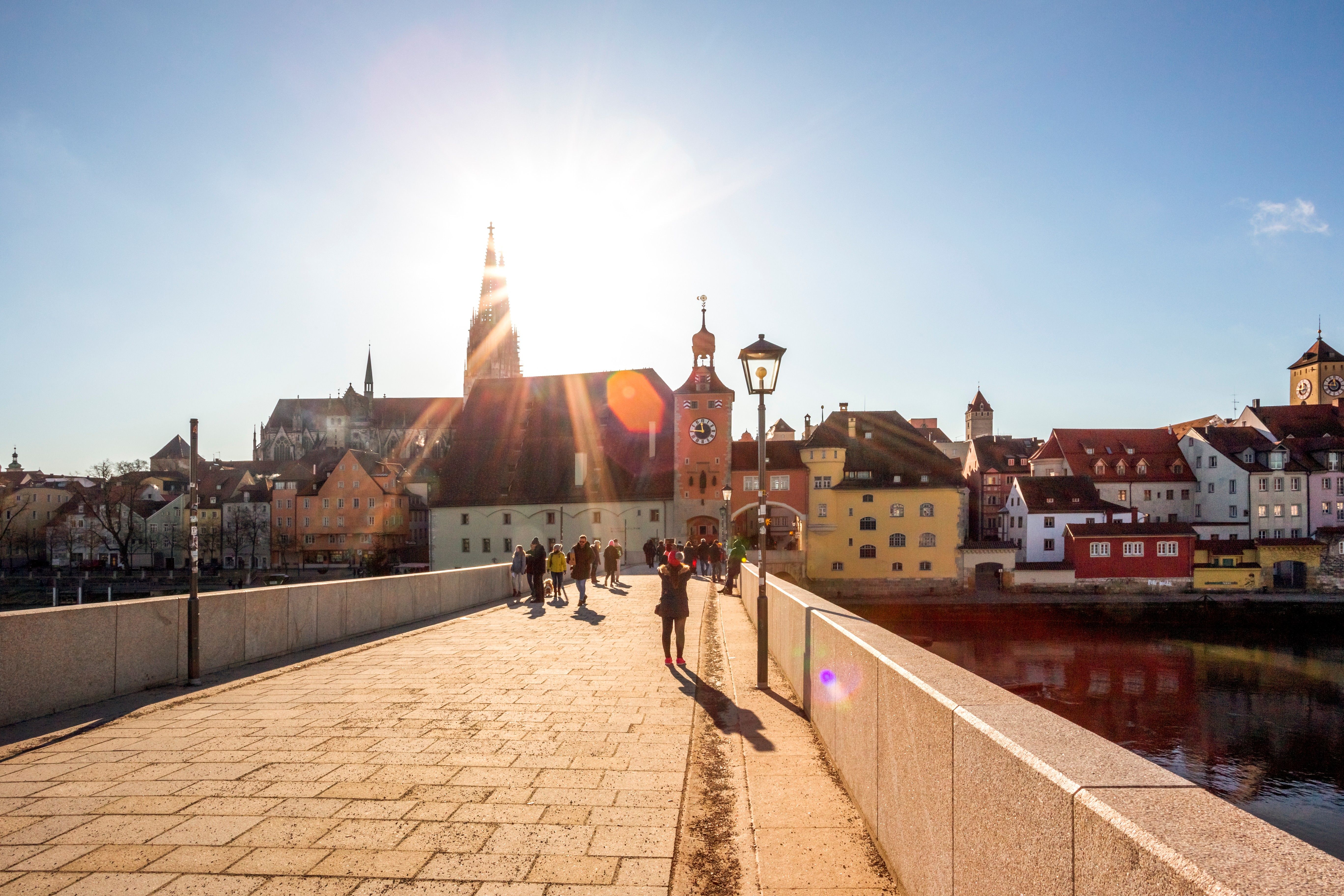 Historische Steinerne Brücke in Regensburg über die Donau, aufgenommen an einem sonnigen Tag.