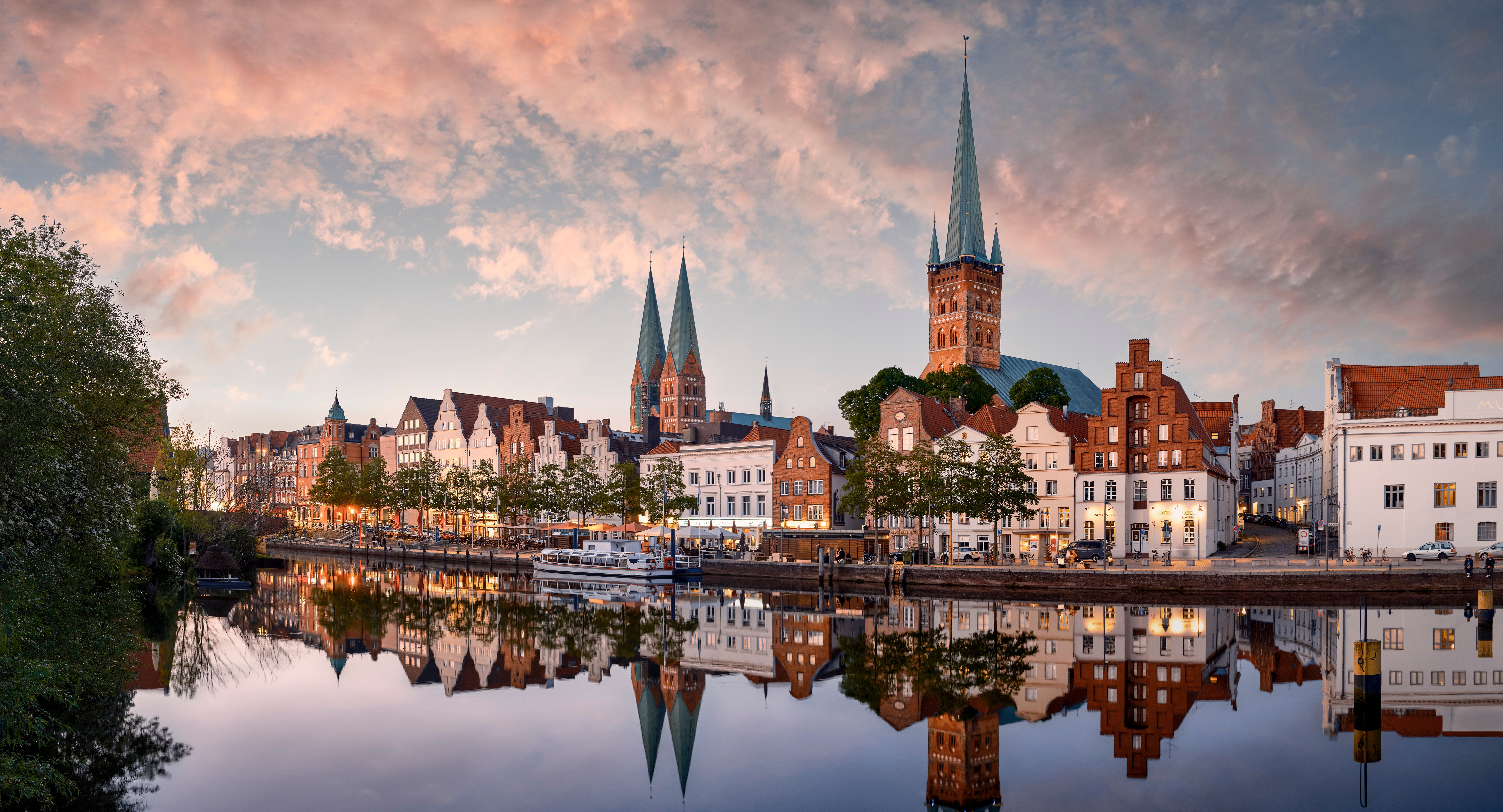 Spiegelung der Altstadt Lübeck im Fluss Trave bei Dämmerung