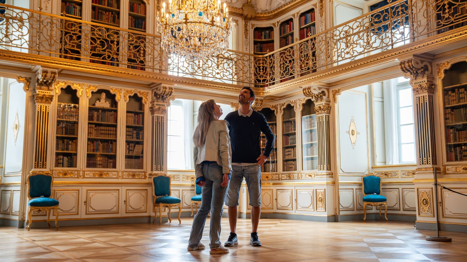 Blick zweier Personen zur Decke und dem Kronleuchter im Schloss Christiansborg