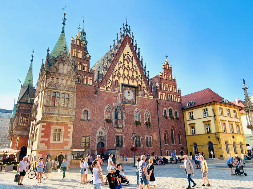 Menschen vor dem Alten Rathaus auf dem Marktplatz in Breslau