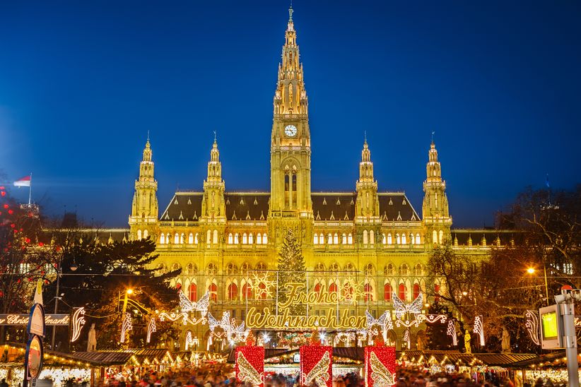 Weihnachtsmarkt in Wien vor dem festlich beleuchteten Rathaus.