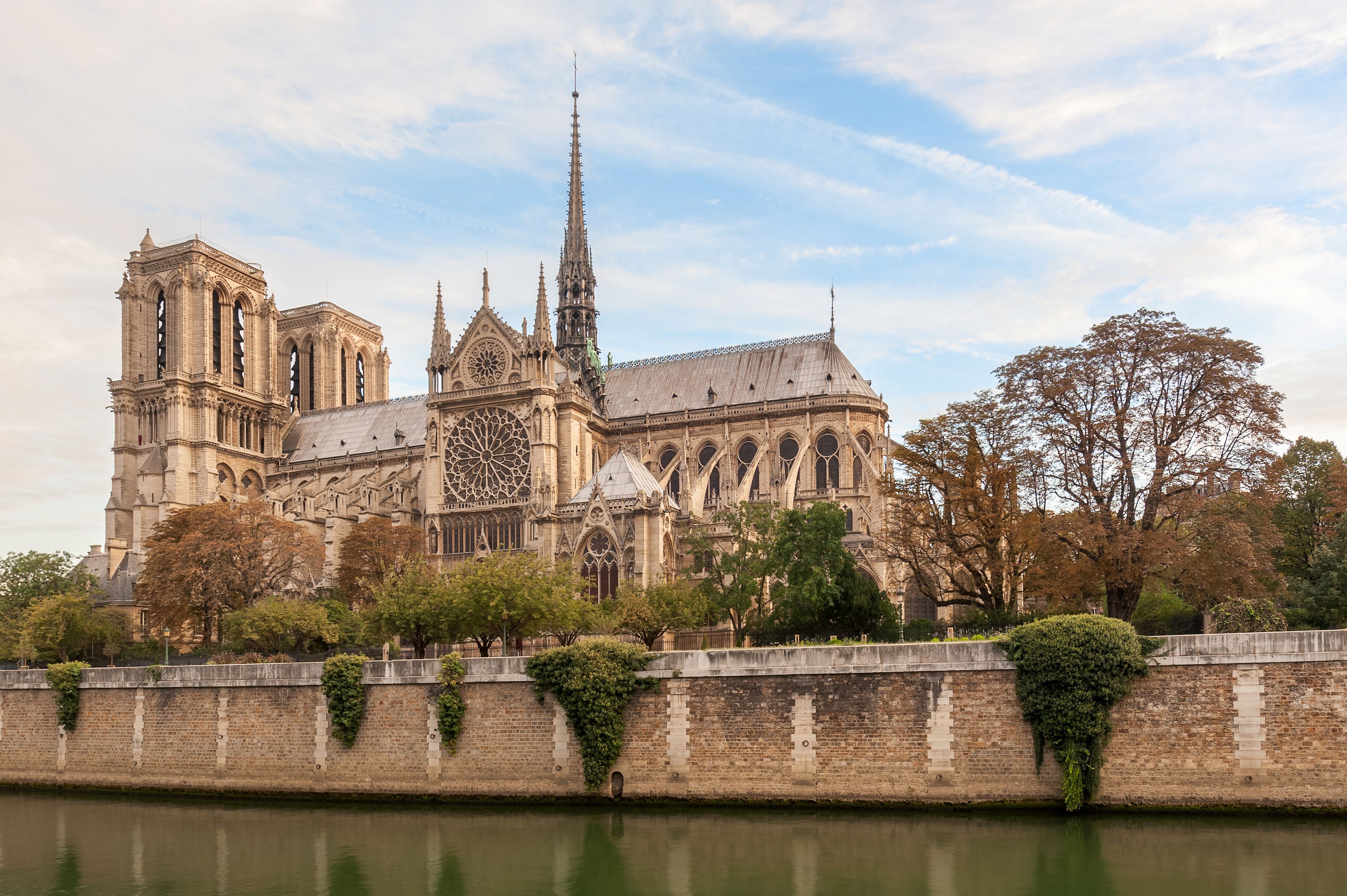 Seitenansicht der Kathedrale Notre Dame in Paris mit dem Fluss Seine im Vordergrund