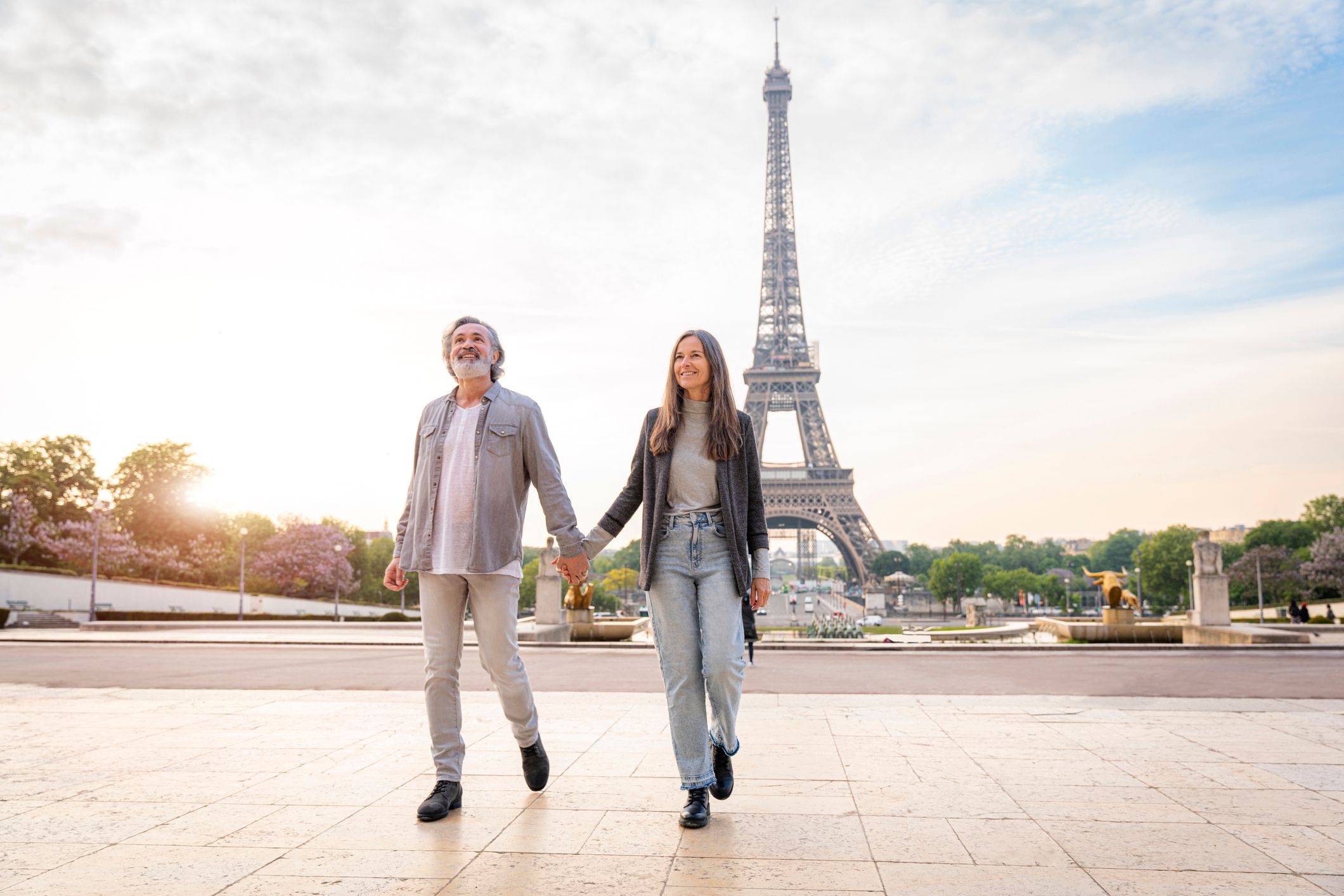 Paar geht Hand in Hand vor dem Eiffelturm in Paris