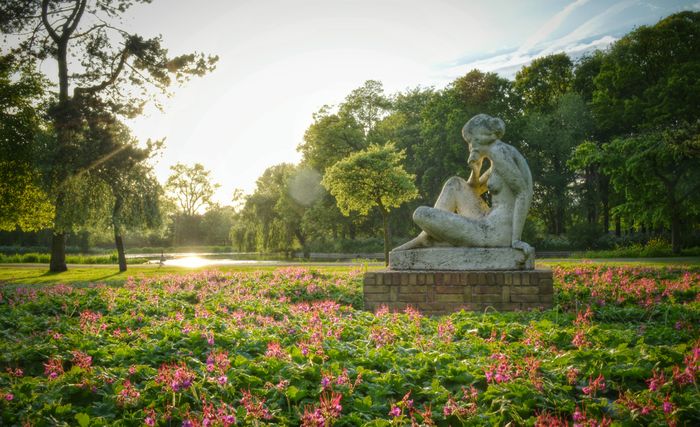 Sitzende Frauenskulptur im Sonnenlicht im Zuiderpark in Den Haag