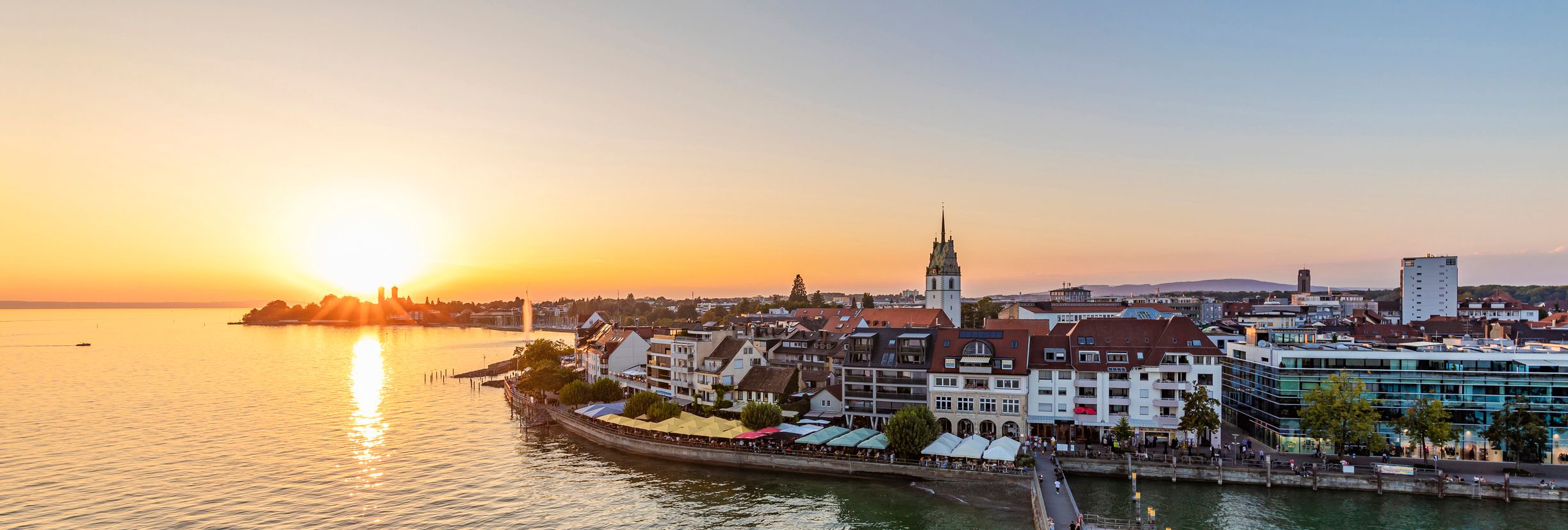 Blick auf Friedrichshafen und den Bodensee bei Sonnenuntergang