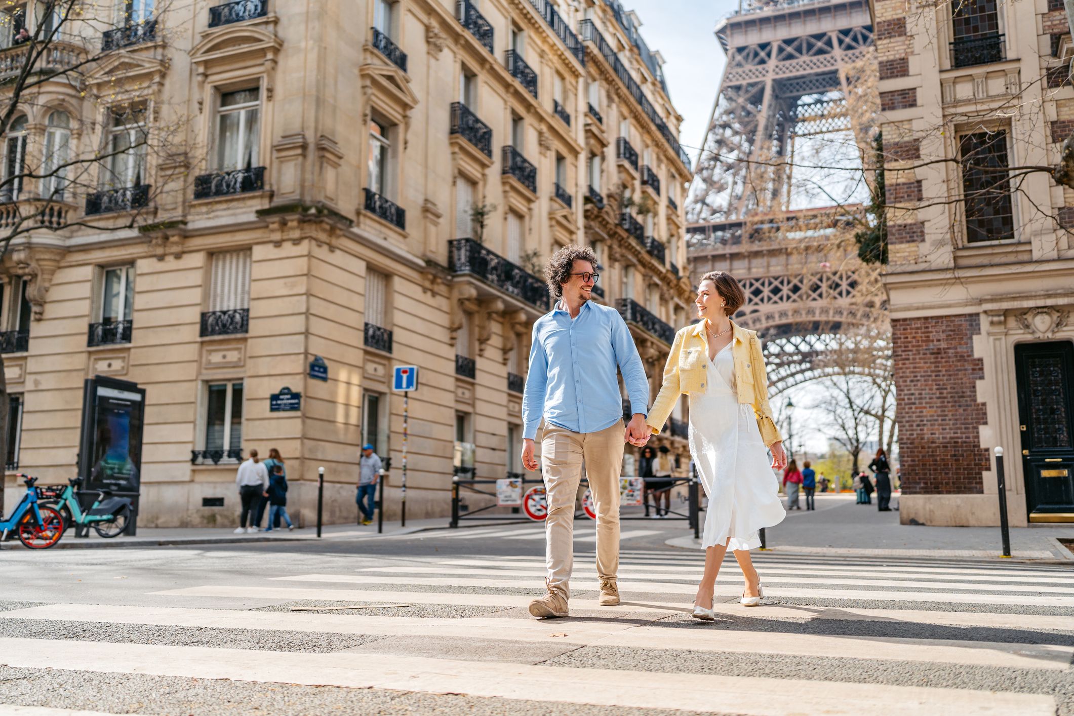 Paar spaziert in Paris über die Straße im Hintergrund der Eifelturm.
