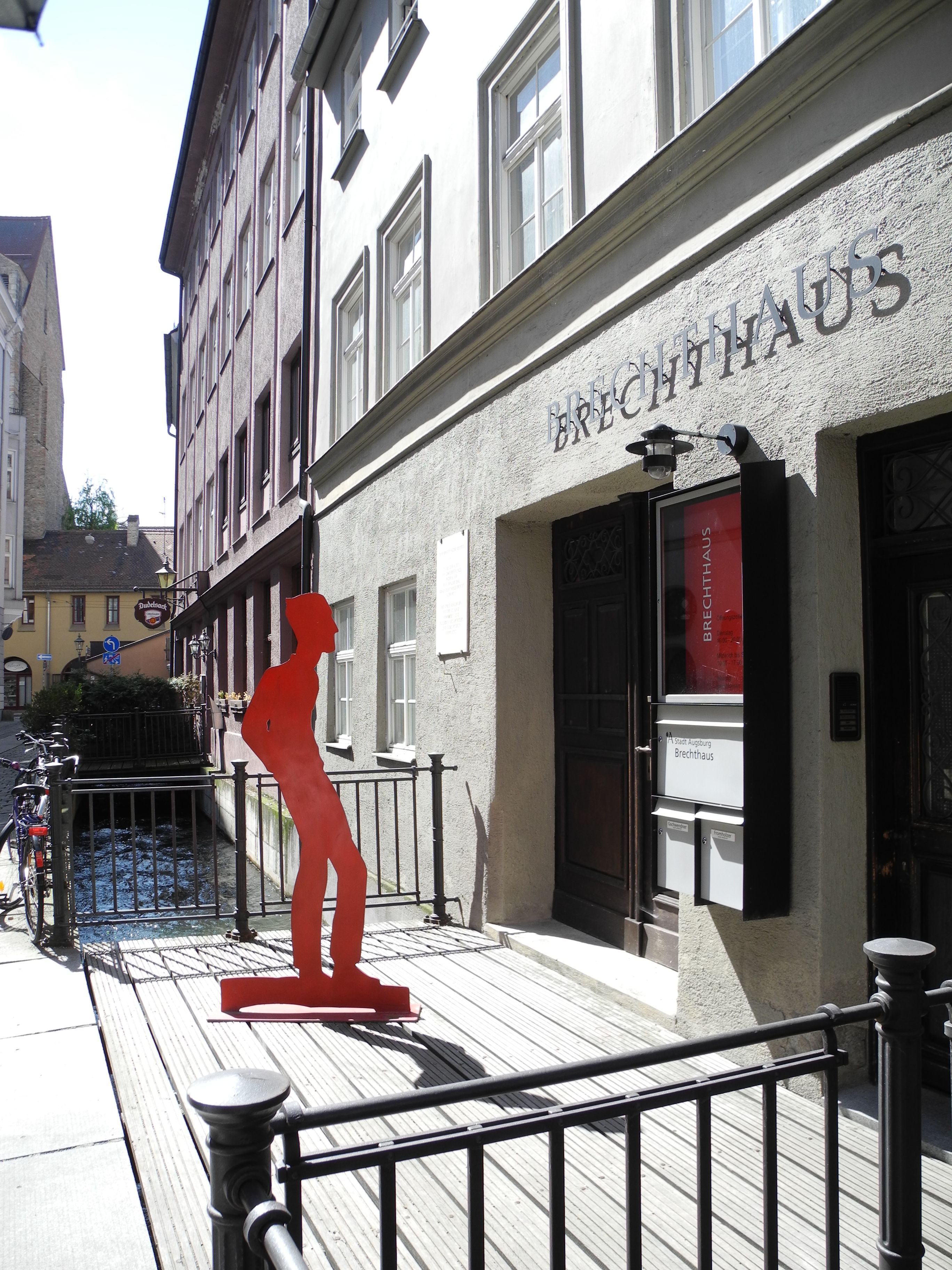 Brechthaus Augsburg mit roter Statue und Bach