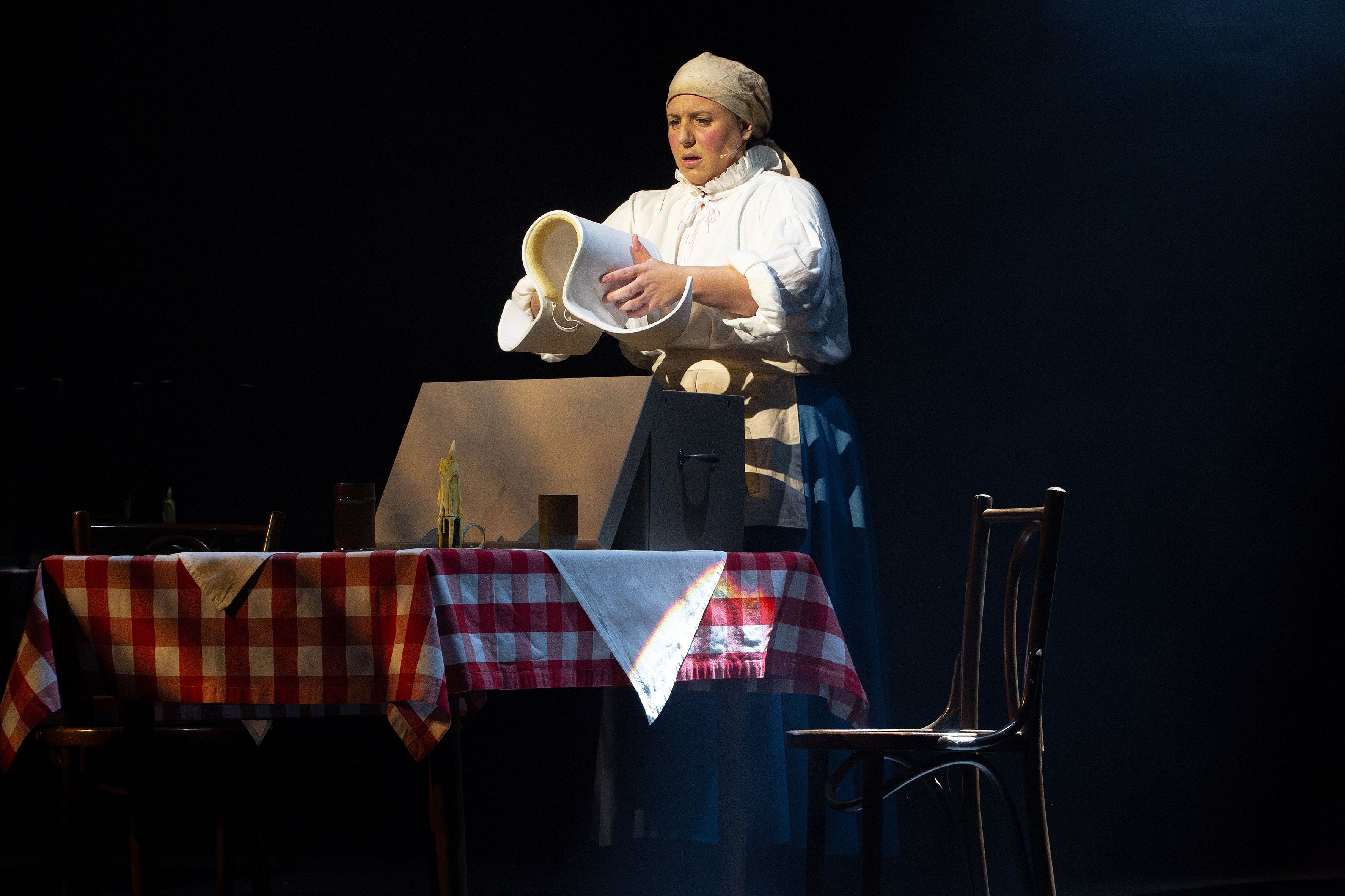 Darstellerin in der Rolle der Amme legt ihren Ammenhut ab im Musical Die Amme